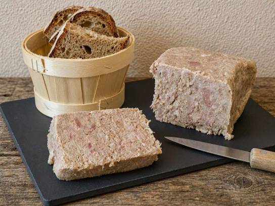 Grillon charentais traditionnel en bloc et sa tranche épaisse sur une planche en ardoise.