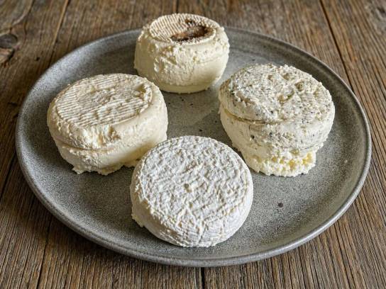 Une assiette rustique contenant des fromages Manslois